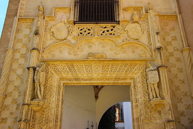 The stone portal of the Puerta de Marchena, with carved figures and coats of arms