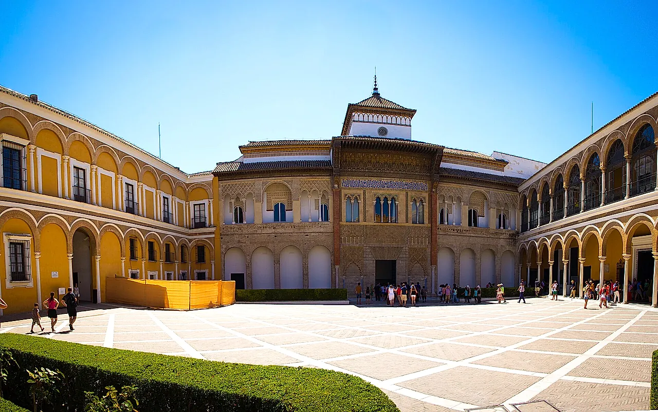 The Patio de la Montería and the facade of Pedro I's palace under a clear blue sky