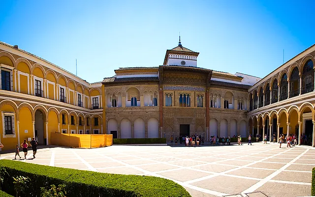 The Patio de la Montería and the facade of Pedro I's palace under a clear blue sky